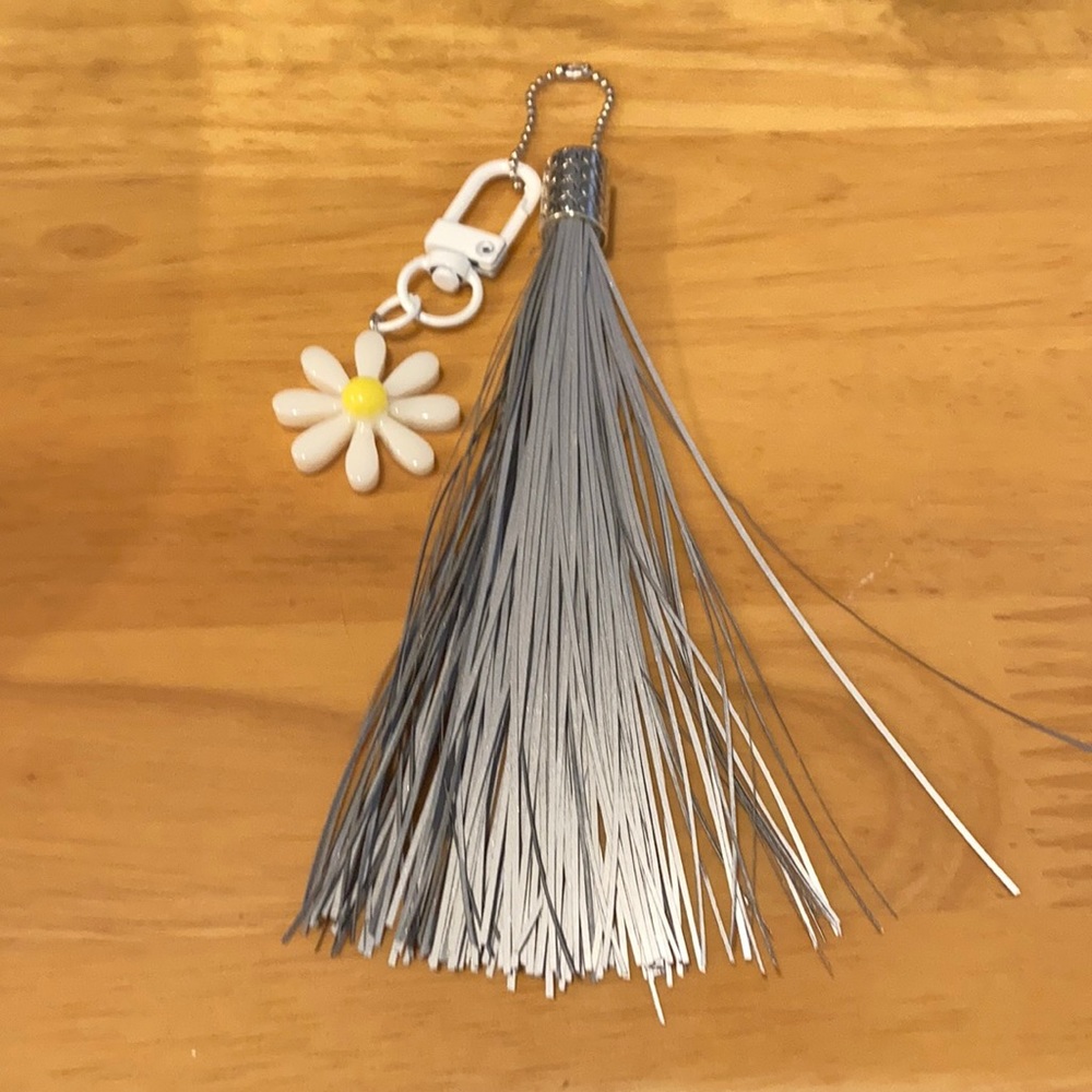 Reflective tassel and daisy charm